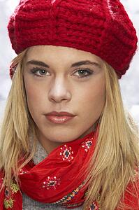 Fashionable Teenage Girl Wearing Cap And Knitwear In Studio In Front Of Christmas Tree