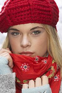 Fashionable Teenage Girl Wearing Cap And Knitwear In Studio In Front Of Christmas Tree