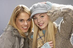 Two Fashionable Teenage Girls Wearing Cap And Knitwear In Studio