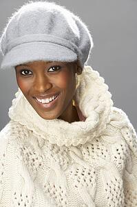 Fashionable Woman Wearing Knitwear And Cap In Studio