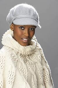 Fashionable Woman Wearing Knitwear And Cap In Studio