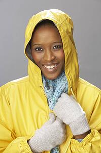 Young Woman Wearing Yellow Raincoat In Studio