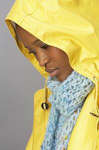 Young Woman Wearing Yellow Raincoat In Studio