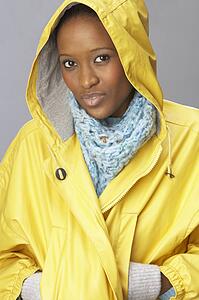 Young Woman Wearing Yellow Raincoat In Studio