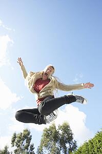 Young Woman Jumping On Trampoline Caught In Mid Air