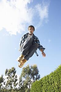 Young Man Jumping On Trampoline Caught In Mid Air