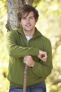 Young Man Outdoors Walking In Autumn Woodland Holding Walking Stick