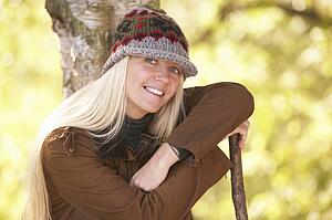 Young Woman Outdoors Walking In Autumn Woodland Holding Walking Stick