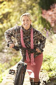Portrait Of Young Woman With Cycle In Autumn Park