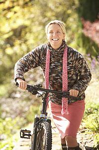 Portrait Of Young Woman With Cycle In Autumn Park