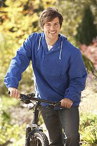 Portrait Of Young Man With Cycle In Autumn Park