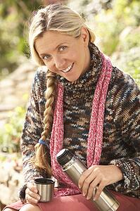 Young Woman Relaxing With Thermos Flask In Autumn Landscape