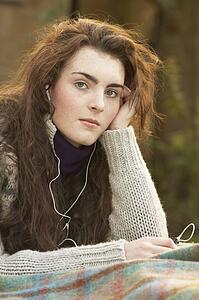 Portrait Of Beautiful Teenage Girl Outdoors Listening To MP3 Player In Autumn Landscape