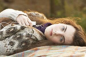 Portrait Of Beautiful Teenage Girl Outdoors Listening To MP3 Player In Autumn Landscape