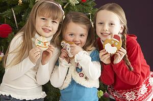 Group Of Young Children With Presents In Front Of Christmas Tree