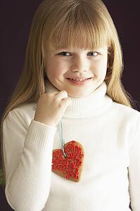 Young Holding Heart Shaped Cookie In Studio