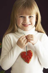 Young Holding Heart Shaped Cookie In Studio