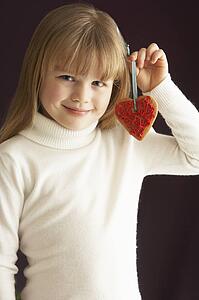 Young Holding Heart Shaped Cookie In Studio