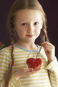 Young Holding Heart Shaped Cookie In Studio