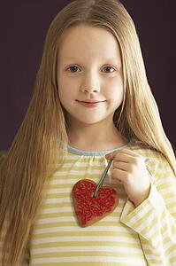 Young Holding Heart Shaped Cookie In Studio