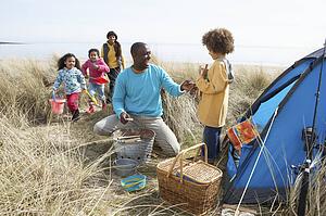 Young Family Relaxing On Beach Camping Holiday