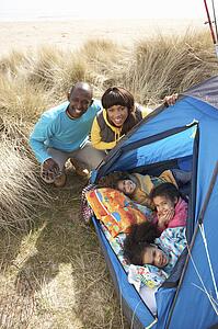 Young Family Relaxing Inside Tent On Camping Holiday