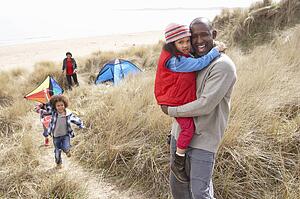 Family Having Fun With Kite In Sand Dunes