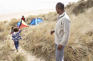 Family Having Fun With Kite In Sand Dunes