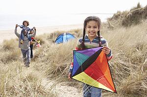 Family Having Fun With Kite In Sand Dunes