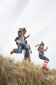 Father And Children Having Fun In Sand Dunes