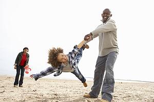 Young Family Relaxing On Beach Camping Holiday
