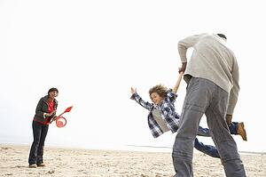 Young Family Relaxing On Beach Camping Holiday