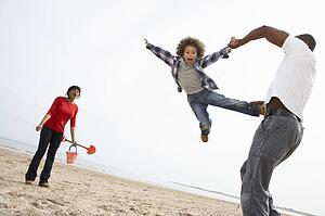 Young Family Relaxing On Beach Camping Holiday