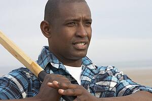 Young Man Playing Cricket On Autumn Beach Holiday