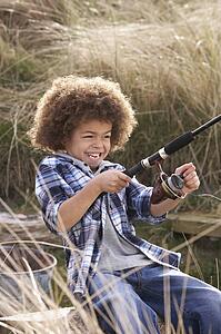 Young Boy Fishing At Seaside