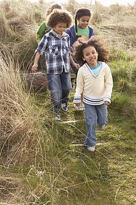 Group Of Children Playing In Field Together
