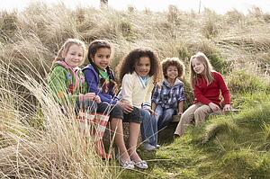 Group Of Children Playing In Field Together