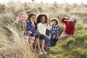 Group Of Children Playing In Field Together