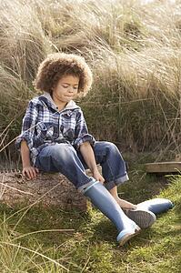 Young Boy Putting On Wellington Boots