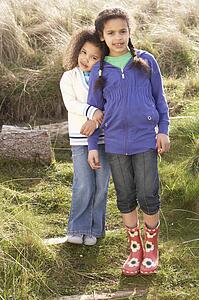 Young Girls Playing In Field Together
