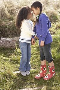 Young Girls Playing In Field Together
