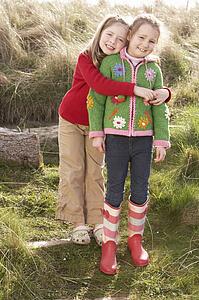 Young Girls Playing In Field Together
