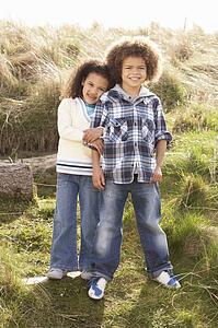 Boy And Girl Playing In Field Together