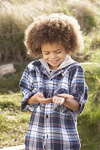 Young Boy Holding Worm Outdoors