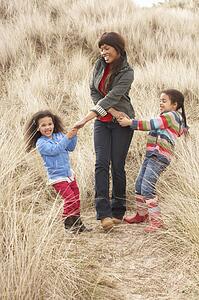 Mother And Daughters Having Fun In Sand Dunes