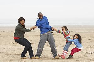 Family Having Fun On Winter Beach