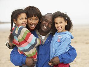 Family Relaxing On Winter Beach Break 