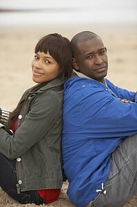 Young Couple Relaxing On Winter Beach Holiday
