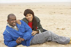 Young Couple Relaxing On Winter Beach Holiday