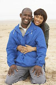 Young Couple Relaxing On Winter Beach Holiday